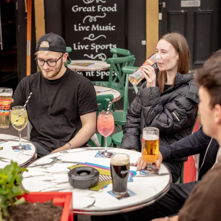 A group of friends enjoying beers and spritzes outdoors