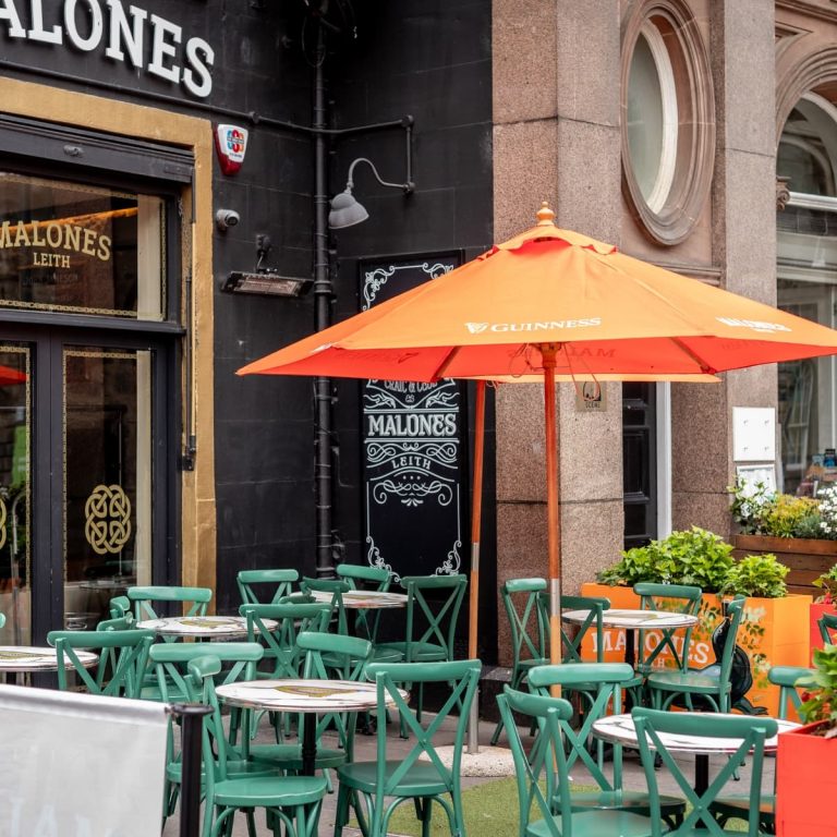 The green seating with an orange umbrella shading the sun